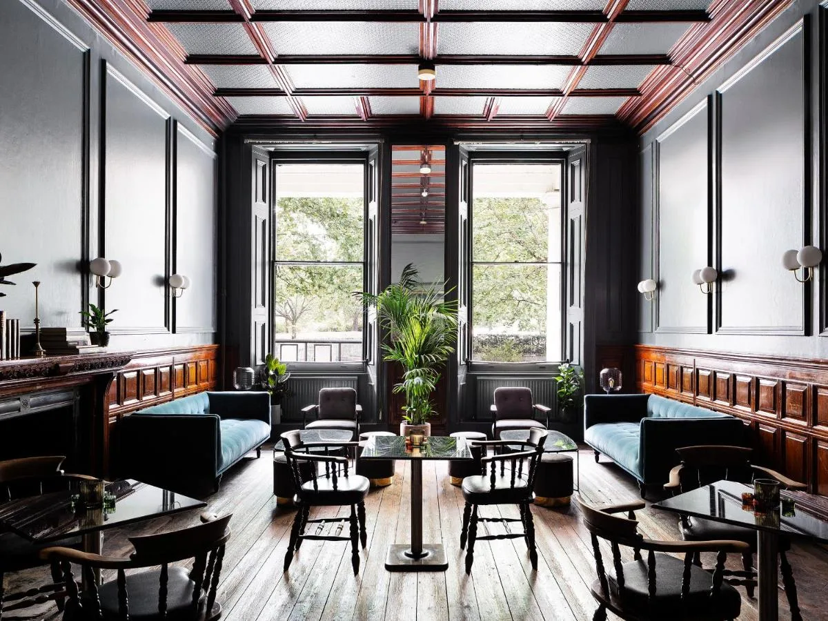 A bright room with a table, chairs and windows at The Columbia Hotel, London