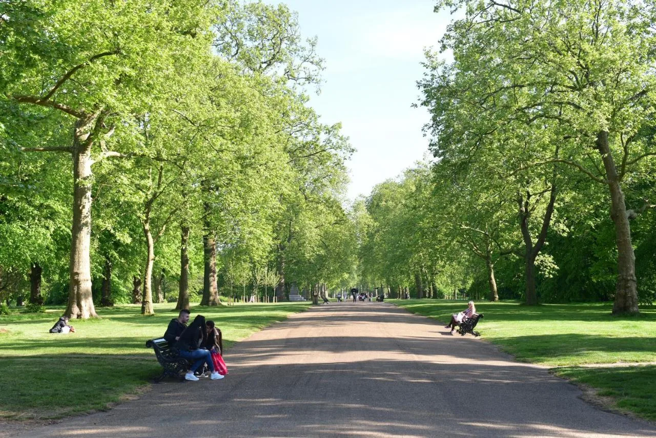 Guests relaxing on benches in Hyde Park, close to The Columbia Hotel
